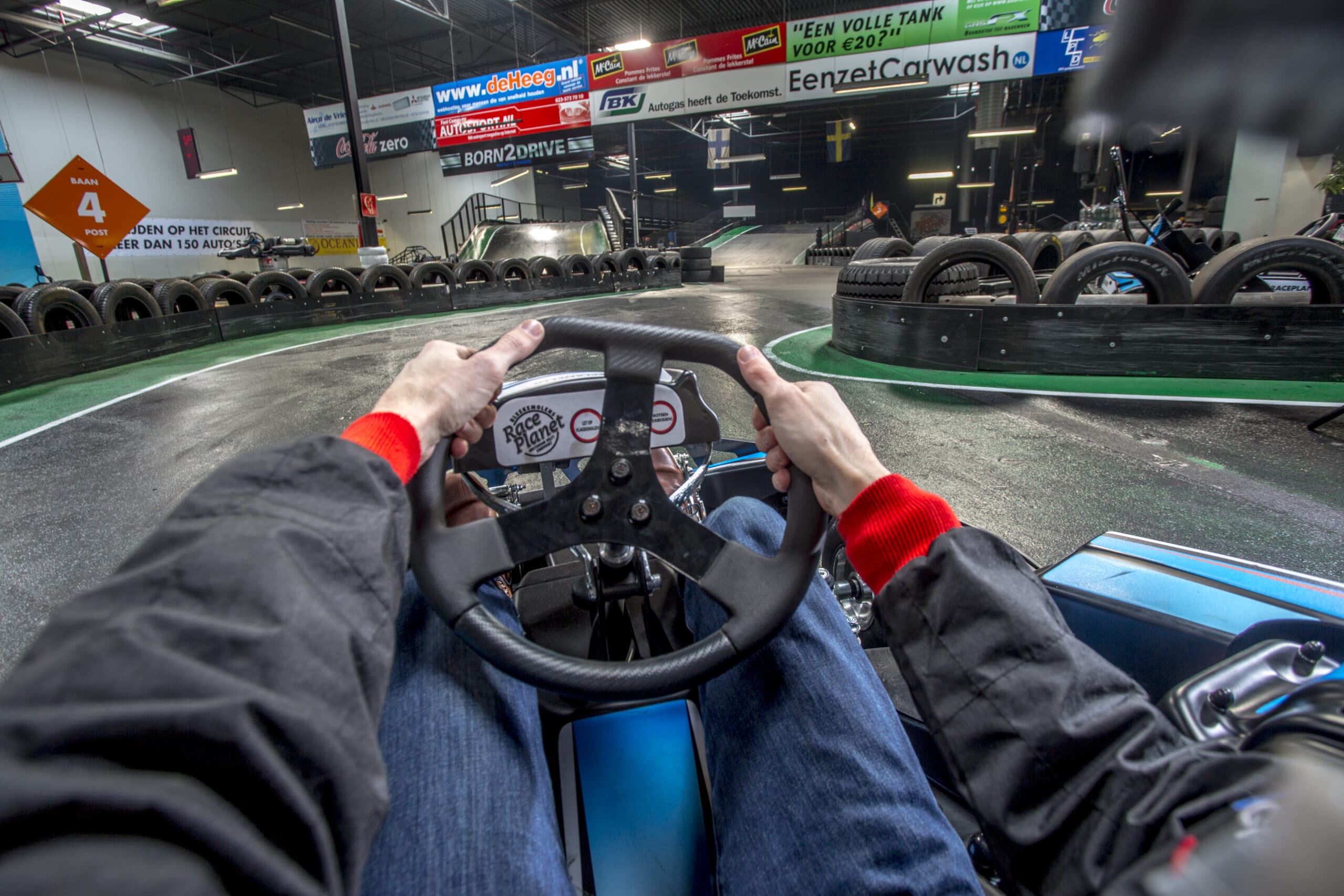 Uitzicht vanuit de kart achter het stuur op de kartbaan van Race Planet in Delft en Amsterdam.