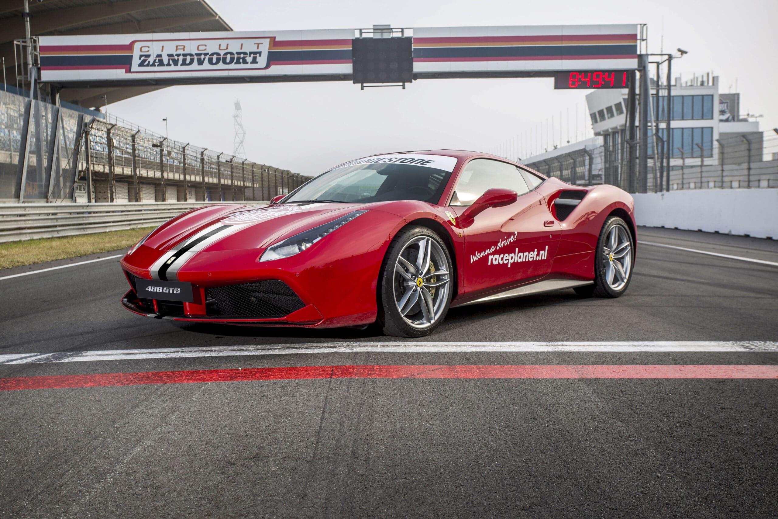 Rode Ferrari 488 GTB op de start-finishlijn van Circuit Zandvoort bij Race Planet.