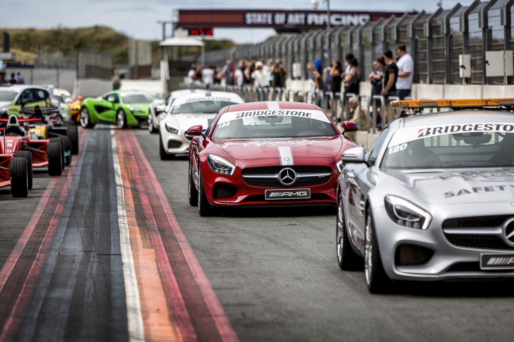 De Race Planet Mercedes-AMG GT's op Circuit Zandvoort in de pitstraat. Deelnemers staan klaar om in te stappen en zelf te rijden in de auto's.