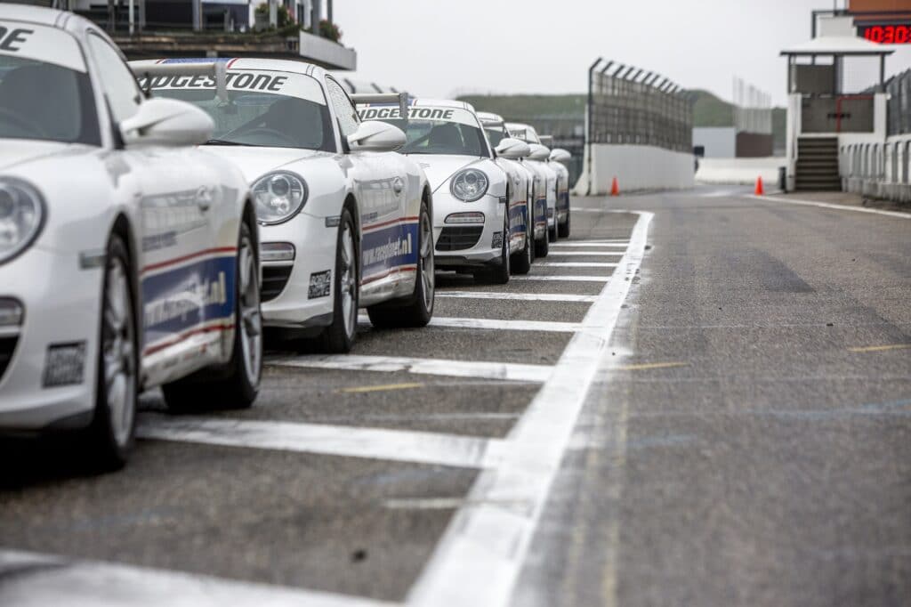 Porsche 911's staan klaar voor de Porsche VIP Experience van Race Planet in de pitstraat op Circuit Zandvoort.