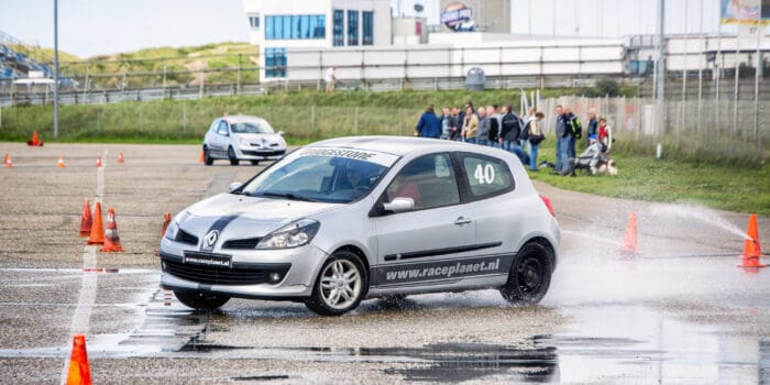 Renault Clio breekt uit in de bocht tijdens de slipproef op nat asfalt tijdens een Race Experience van Race Planet op Circuit Zandvoort.