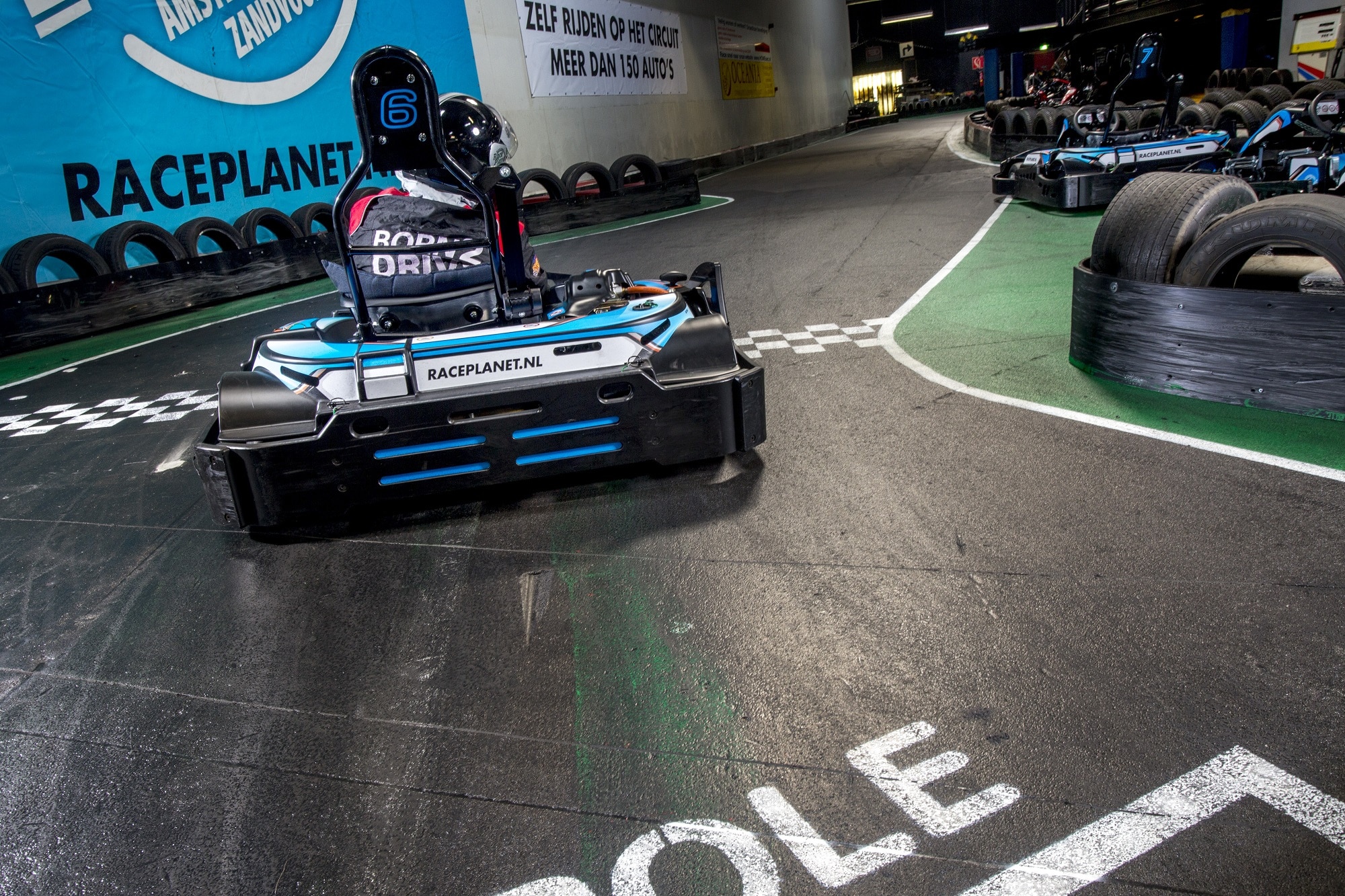 Een kart racet over de finish lijn bij de kartbaan van Race Planet Amsterdam en Delft.