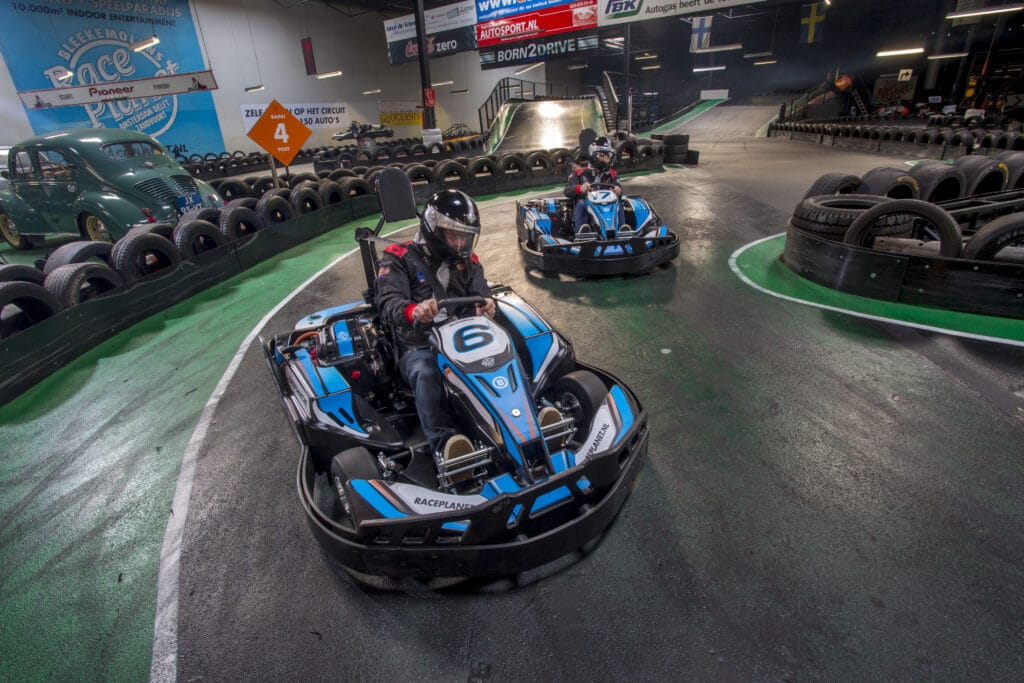 Karters racen tegen elkaar op de kartbanen van Race Planet in Amsterdam en Delft