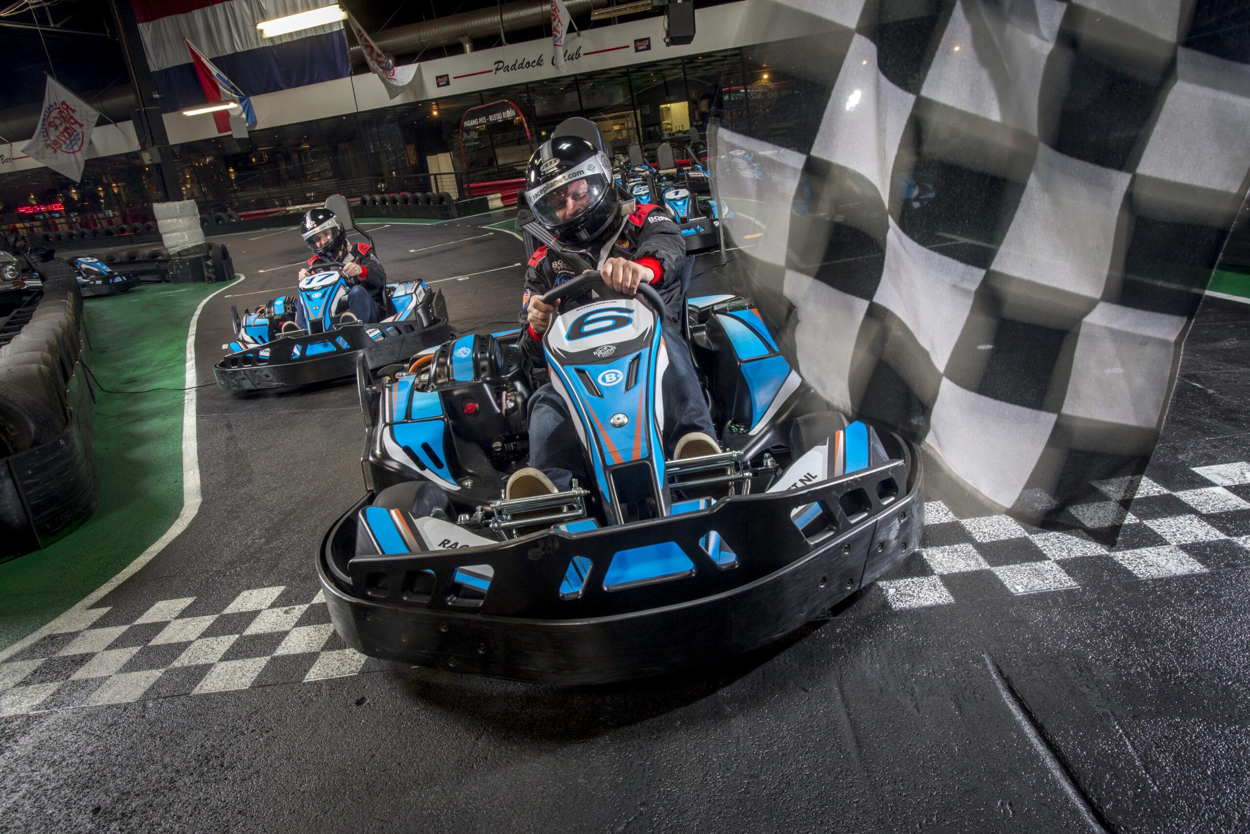 Coureurs racen op de kartbaan van Race Plant in Delft en Amsterdam tegen elkaar over de finishlijn.